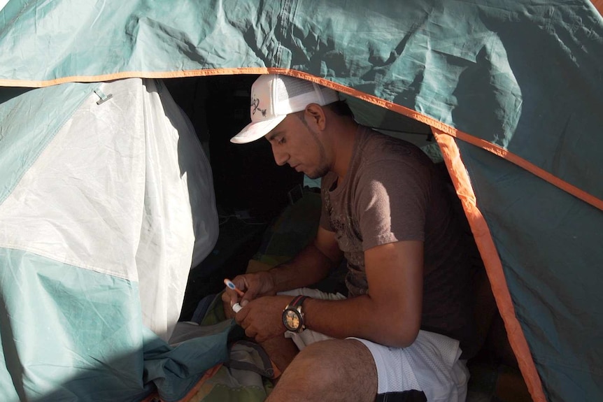 El Salvadorian migrant Herbert Zometa sitting in his tent at a shelter in Tijuana