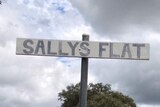 A 'Sallys Flat' sign by the side of a rural road
