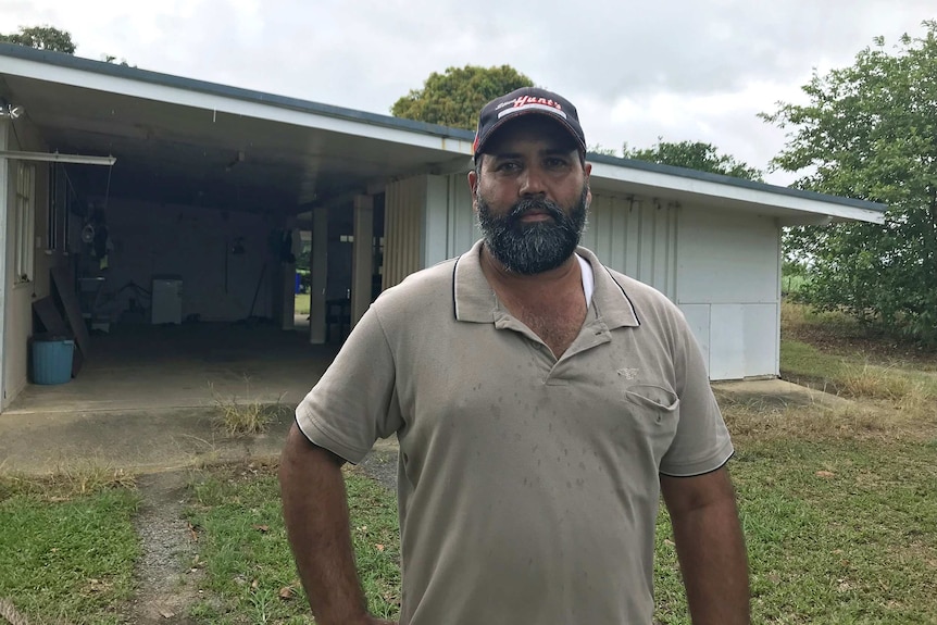 Harpreet Singh stands outside a house.