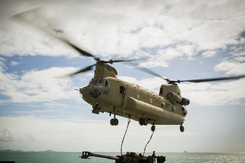 Chinook helicopter winching a gun.