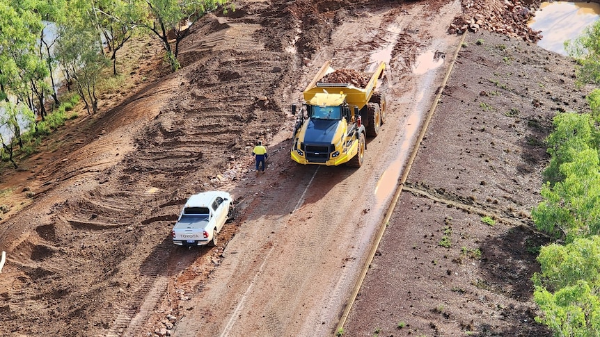 An aerial shot of trucks repairing damaged road