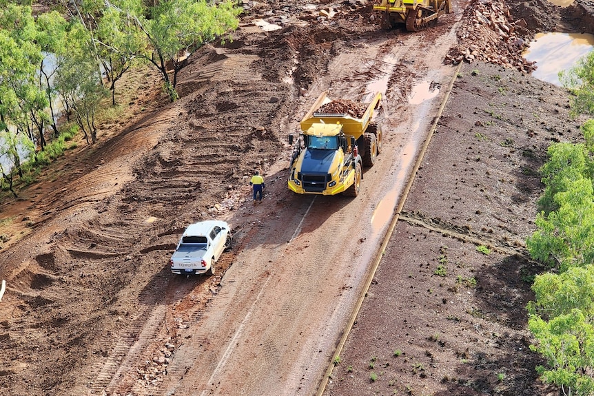 An aerial shot of trucks repairing damaged road
