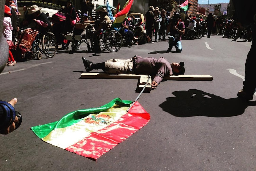 A protester attaches himself to a crucifix.