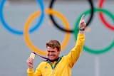 Tom Slingsby holds the gold medal he won in the men's Laser class sailing competition.
