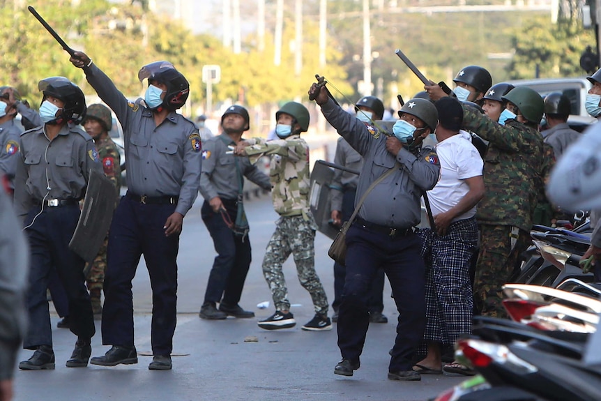 A policeman aims a slingshot.