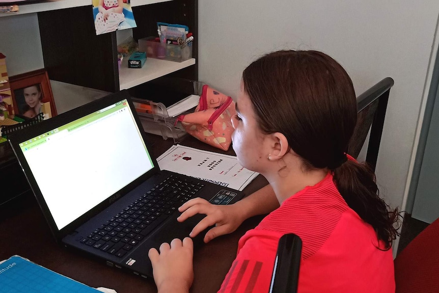 A Year 7 student sitting in front of a computer in her bedroom