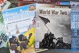 Various history books are seen on a tabletop. One is about World War Two and another Indigenous Australians and Captain Cook.