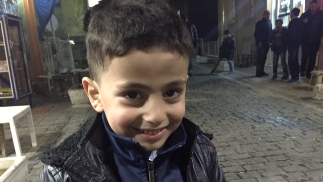 Syrian boy Omar smiles as he poses for the camera.