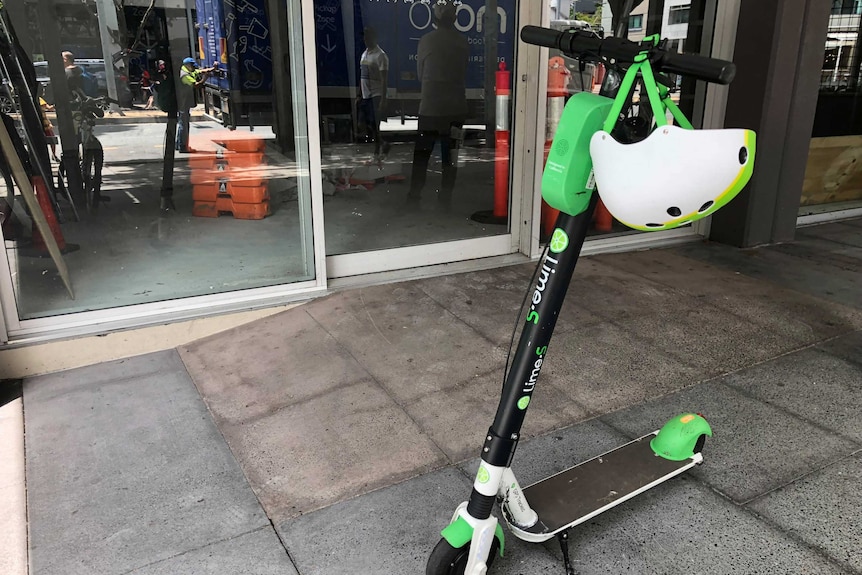 A Lime scooter parked on a sidewalk in Brisbane.