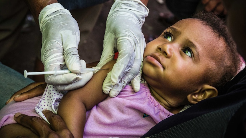 A child is immunised during a polio vaccination drive in PNG