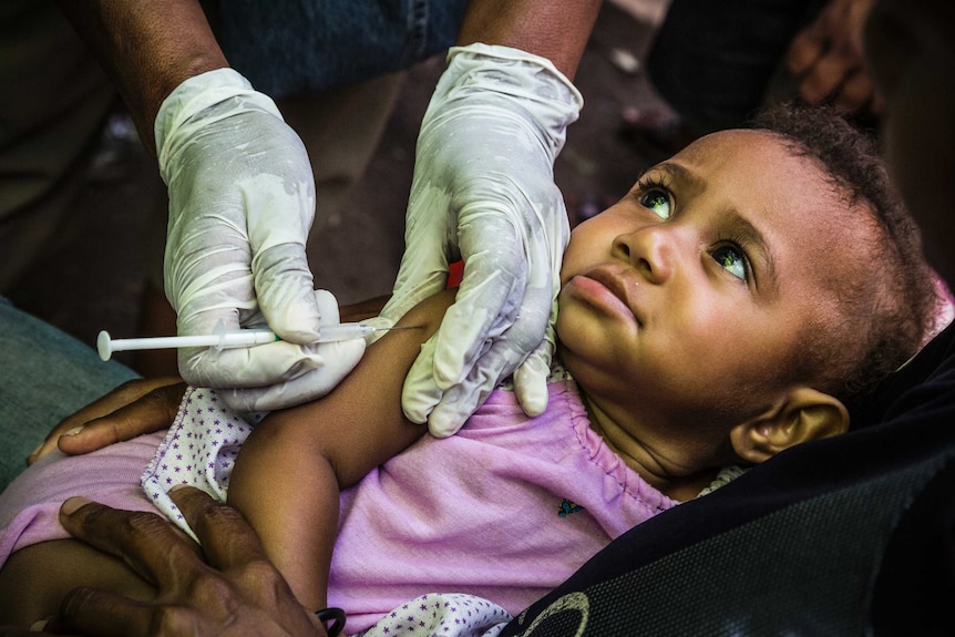 A child receives an immunisation at the launch of a polio vaccination drive.