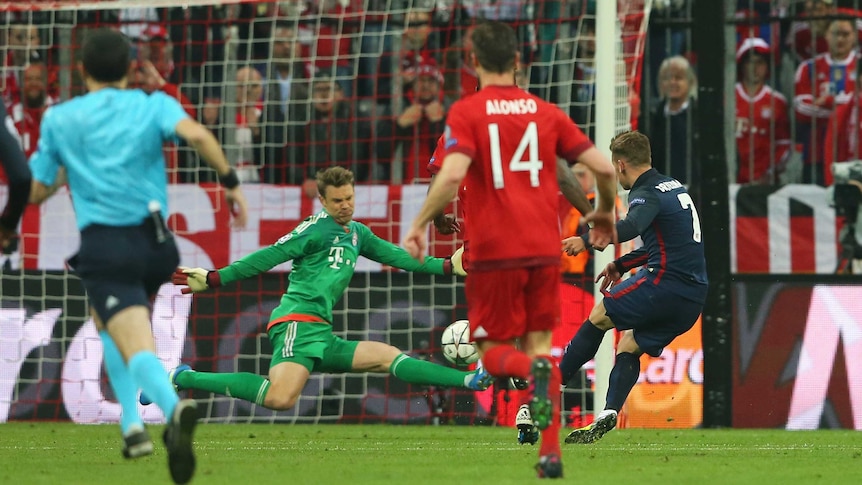 Atletico Madrid's Antione Griezmann (7) scores on Bayern Munich's Manuel Neuer in Champions League.