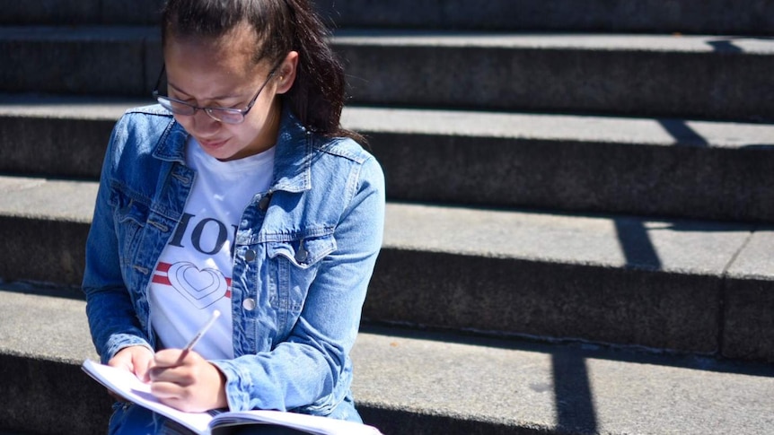 19-year-old Annika McCaffrey sits on the steps of St Paul's Cathedral.