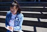 19-year-old Annika McCaffrey sits on the steps of St Paul's Cathedral.