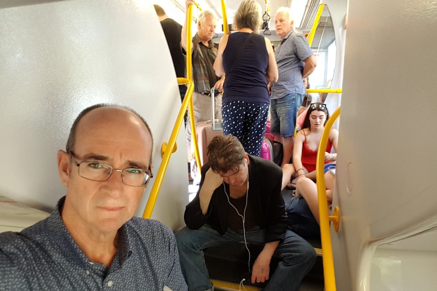 Selfie image of man on busy passenger train