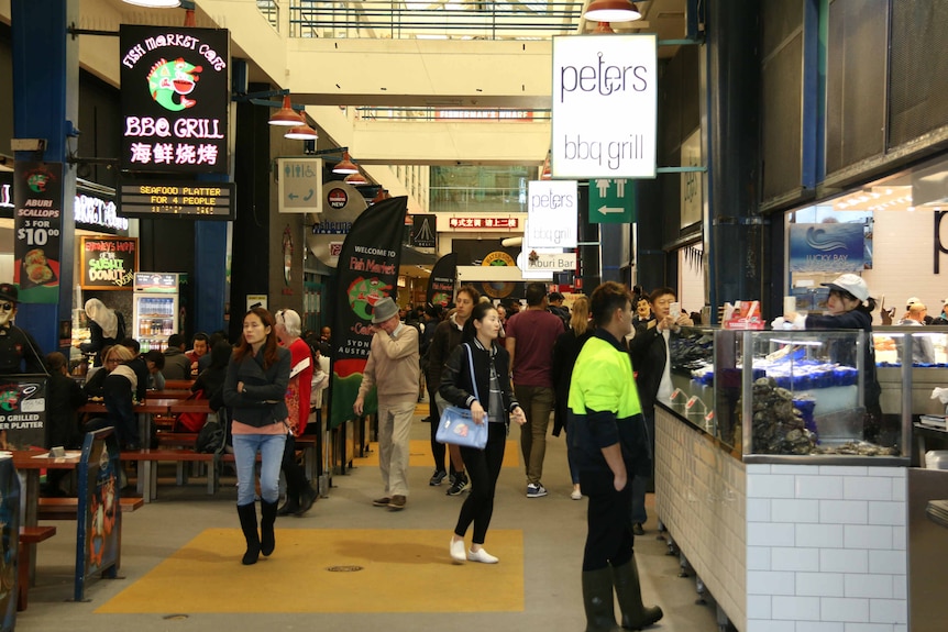 Crowds wander through the Sydney fish market.