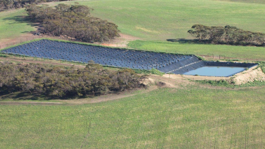 A picture of a water dam that uses sheets of plastic that collects the water on top and then the water runs down to a big dam.