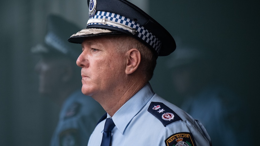 police commissioner mick fuller looking stern next to a reflection