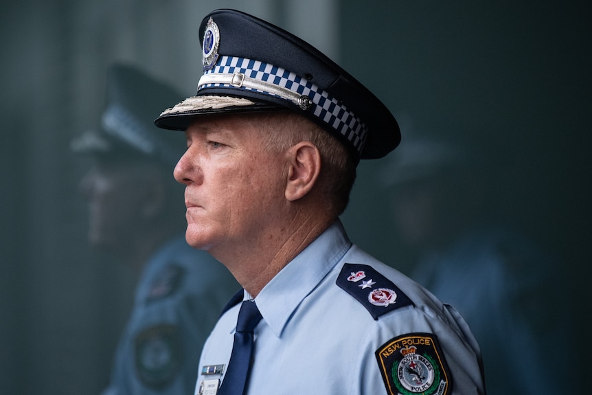 police commissioner mick fuller looking stern next to a reflection