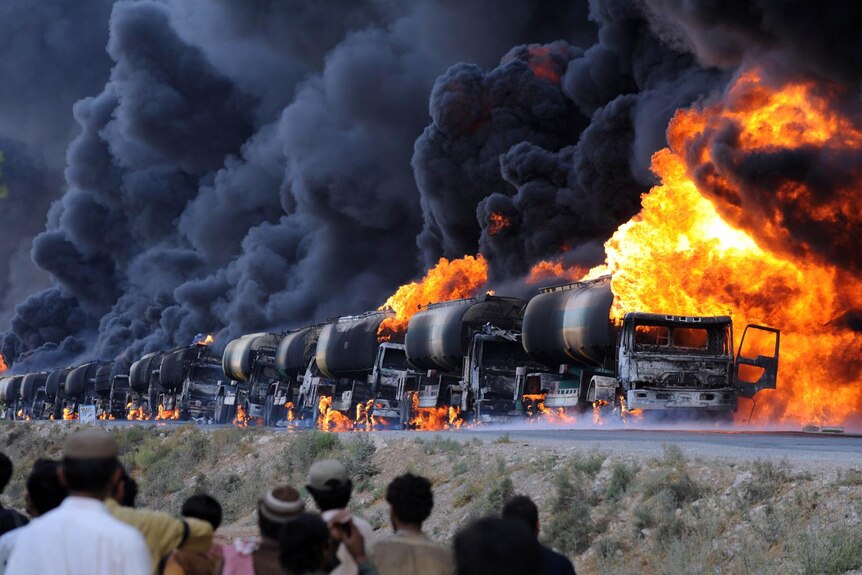 A row of NATO oil tankers burn following an attack by gunmen in Pakistan