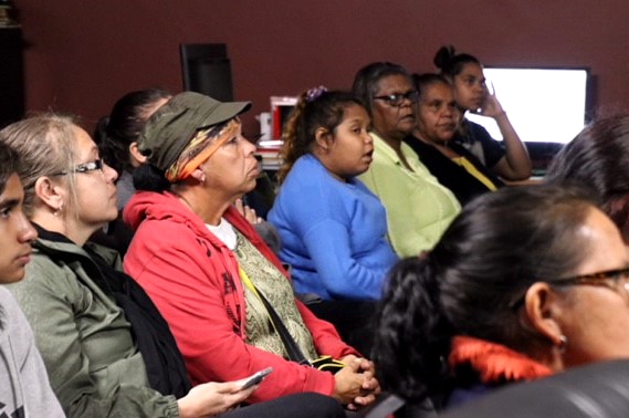 A group of mostly aboriginal people listen to a presentation.