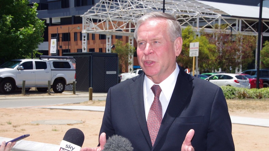 Colin Barnett speaks to a bunch of microphones.
