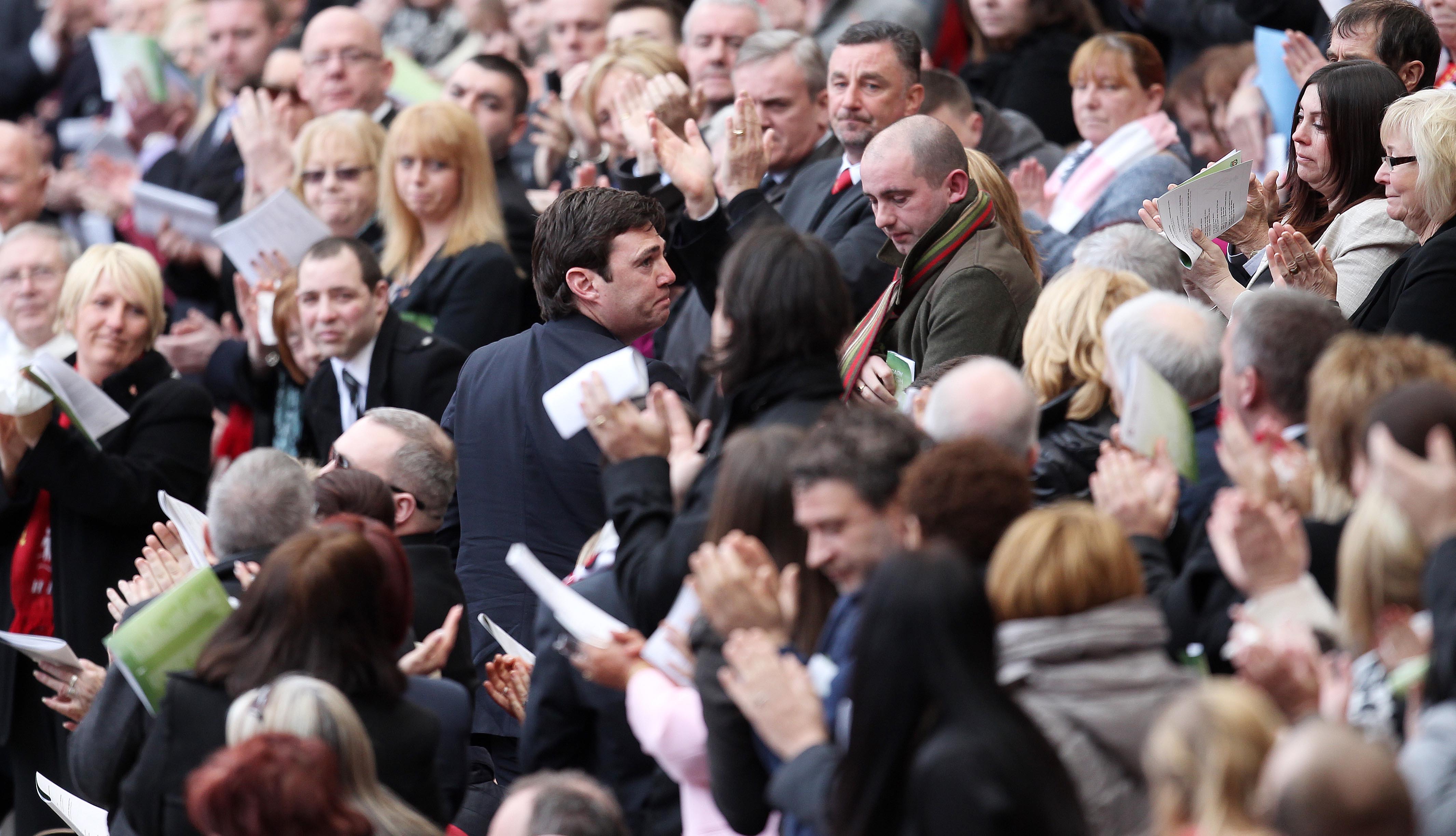 A crowd claps the man in the centre.