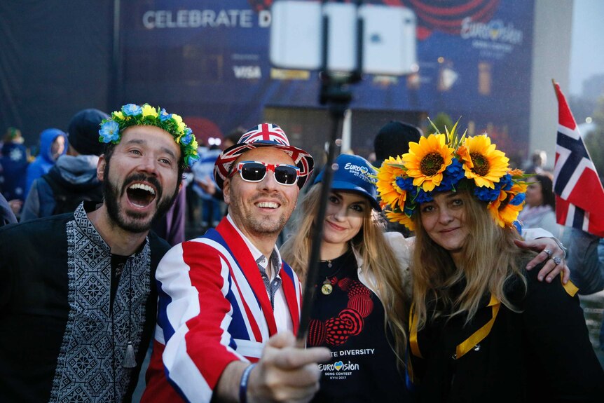 Four eurovision fans took selfies outside the venue, donning flower crowns and the union jack