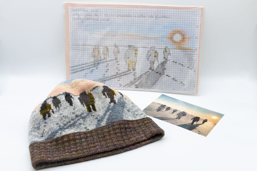 A photo of Antarctic explorers walking across ice sits next to a beanie depicting the same photo.