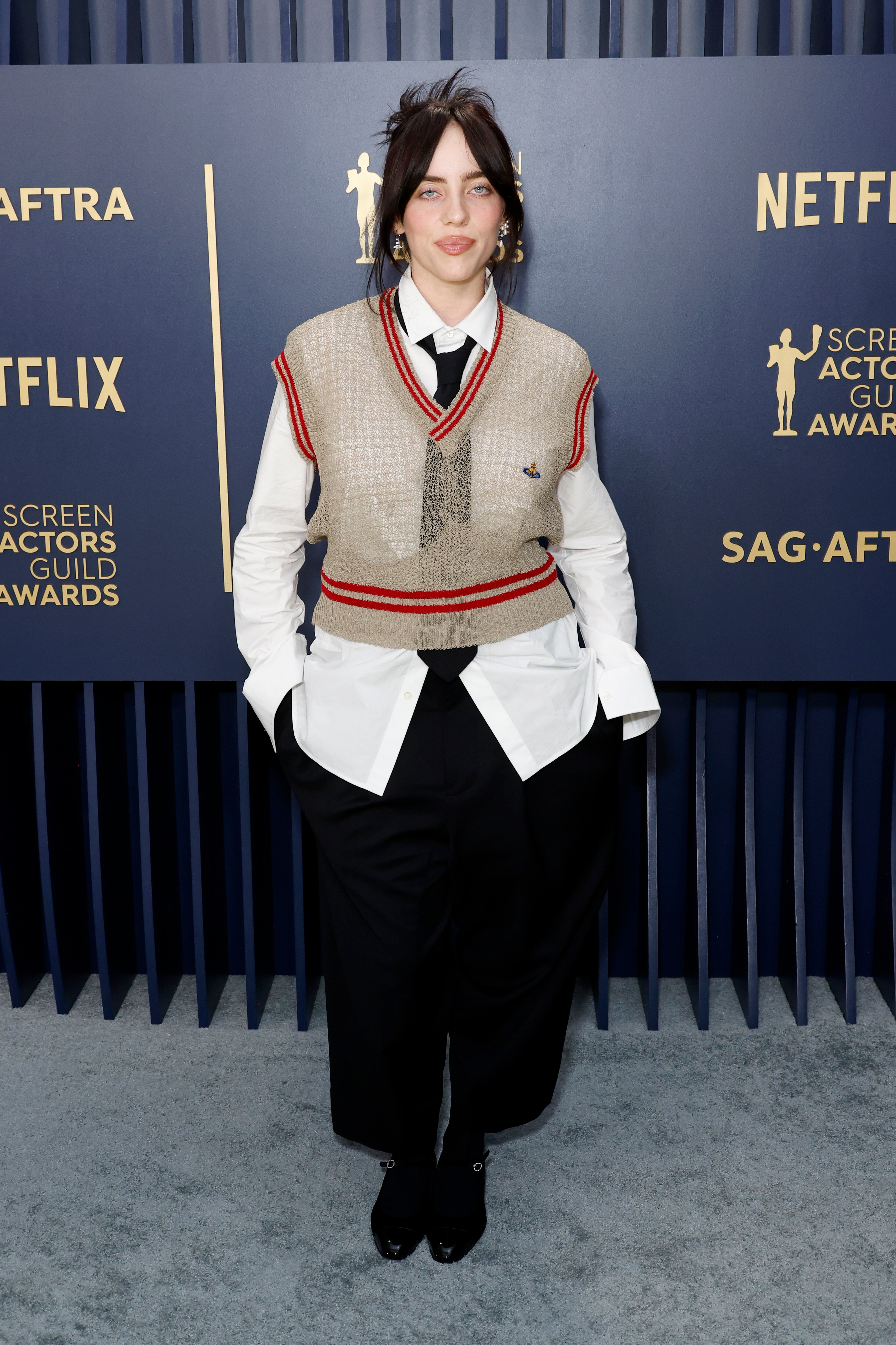 Woman wears a brown vest over white shirt and black pants