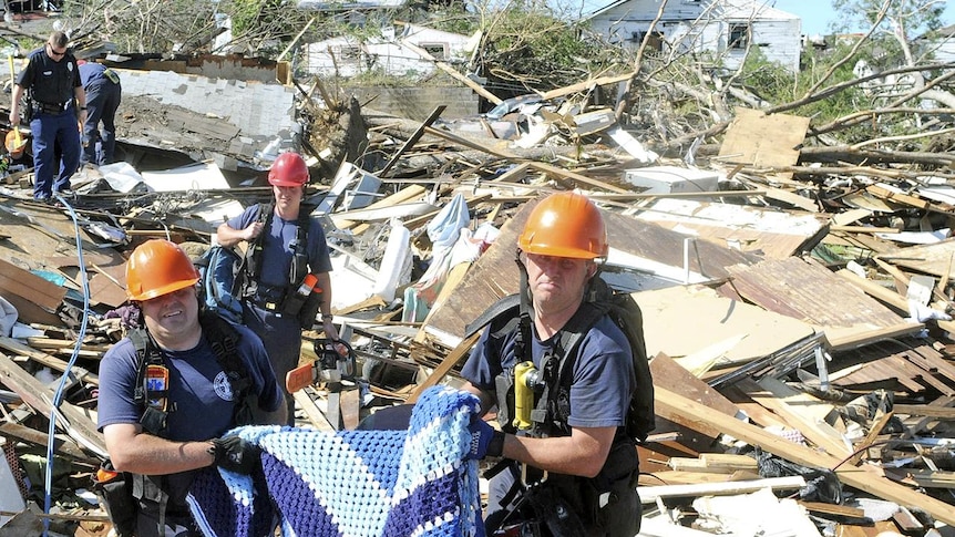 Birmingham Fire and Rescue members carry an injured dog they rescued from a house in Pratt City, Alabama.