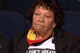 A woman with dark curly hair, wearing a shirt that says 'I can't breathe' appears on Q+A