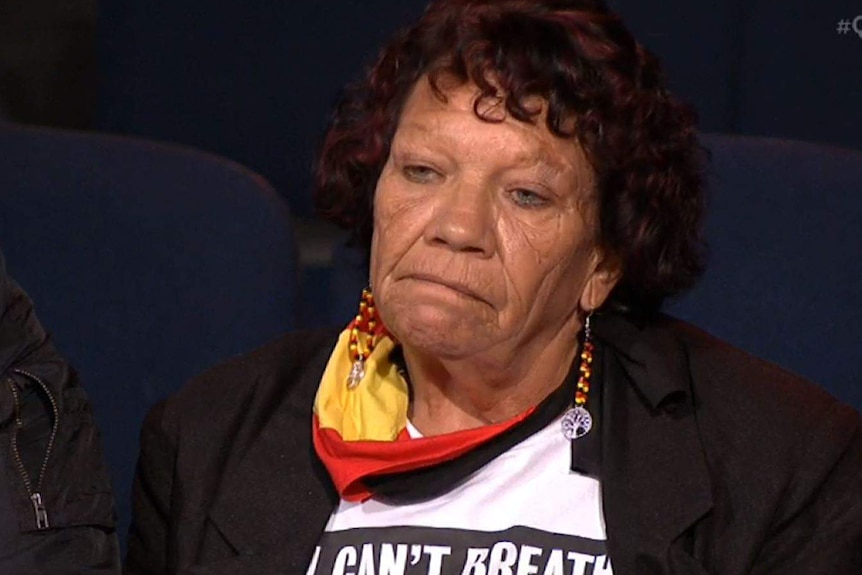 A woman with dark curly hair, wearing a shirt that says 'I can't breathe' appears on Q+A