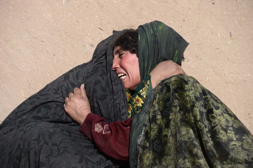 An Afghan mother weeps for her son who was killed in a series of explosions near the city of Herat, Afghanistan