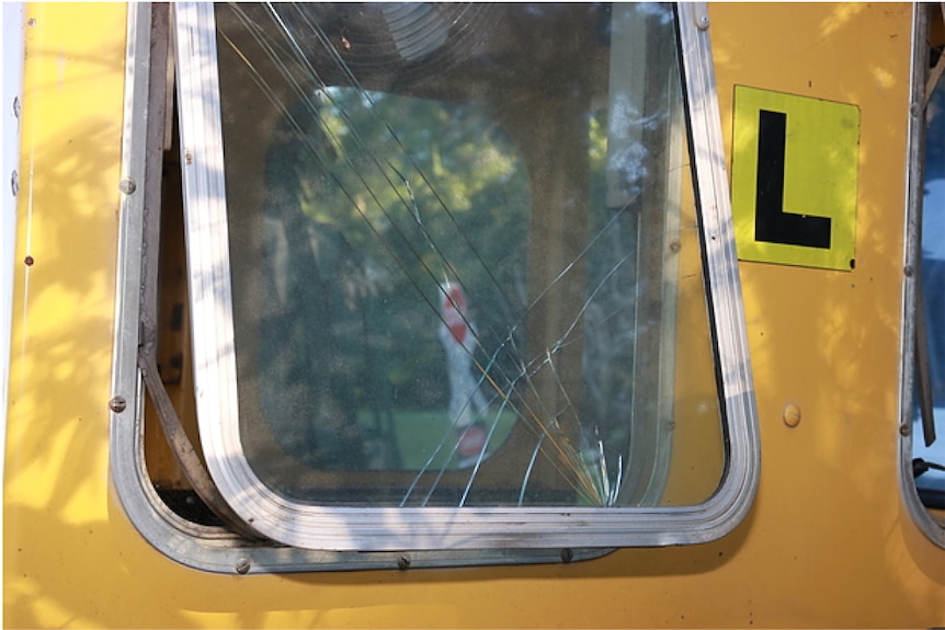 Une fenêtre de train fêlée, légèrement entrouverte.