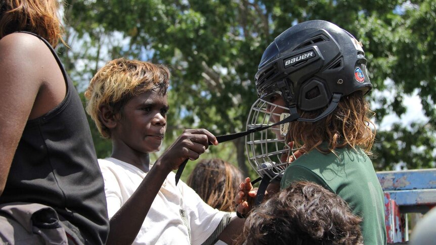 A young Aboriginal rider gets ready for a poddy calf ride at Mataranka in the Northern Territory. Helmets must be worn.