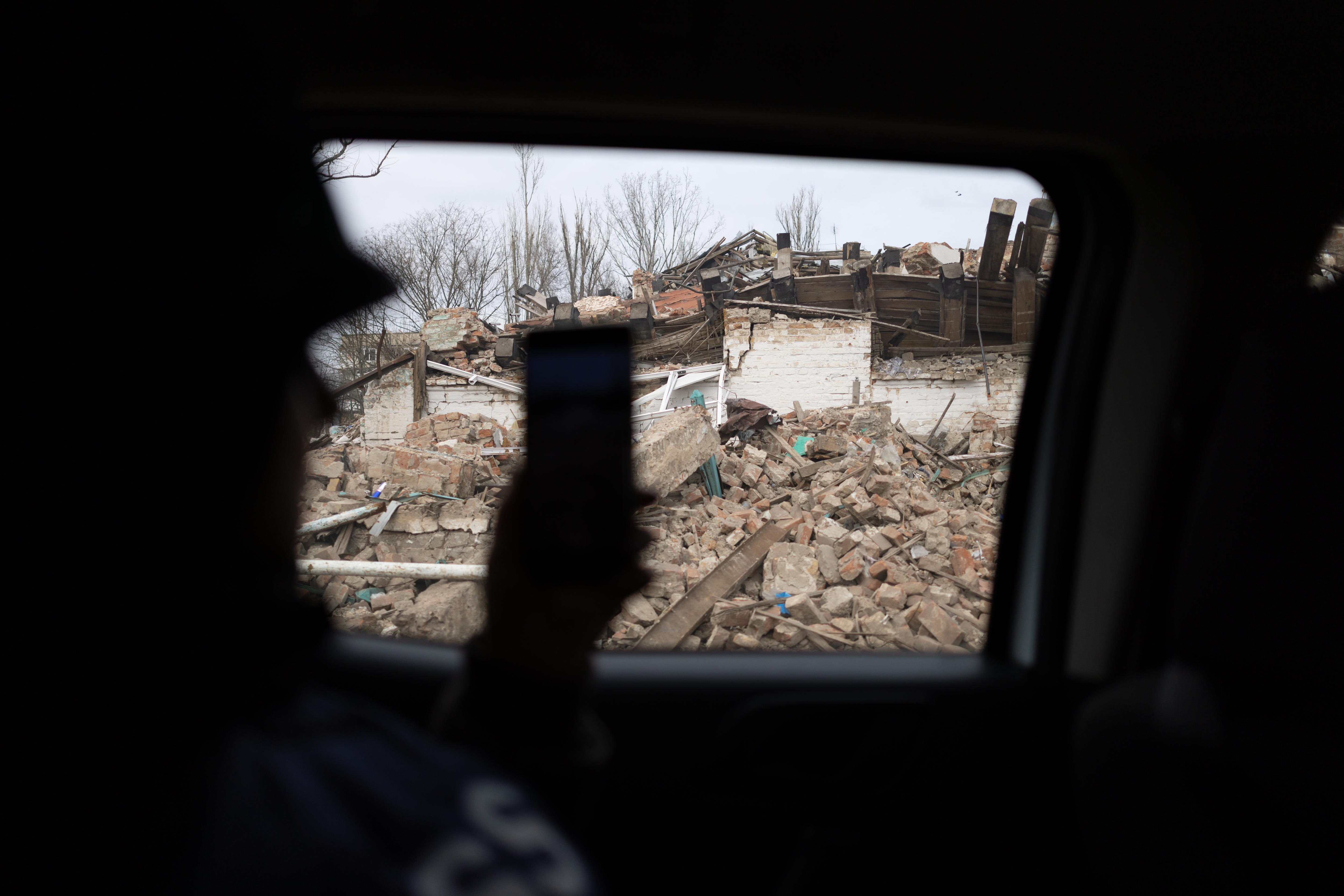 A woman filming out a car window.