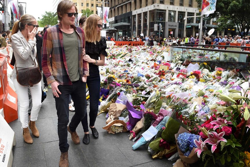 Grieving families of Tori Johnson and Katrina Dawson visit floral tribute in Martin Place.