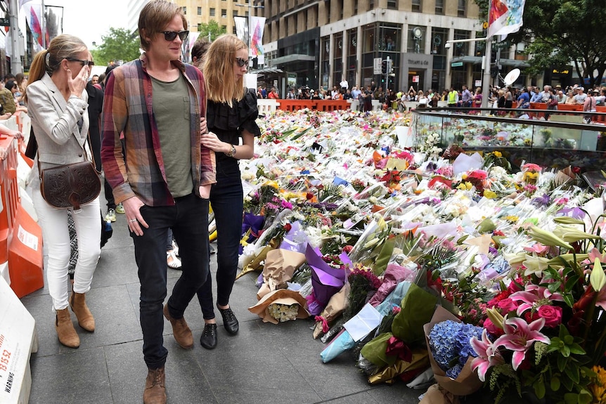 Relatives of Tori Johnson and Katrina Dawson visit the floral memorial at Martin Place.