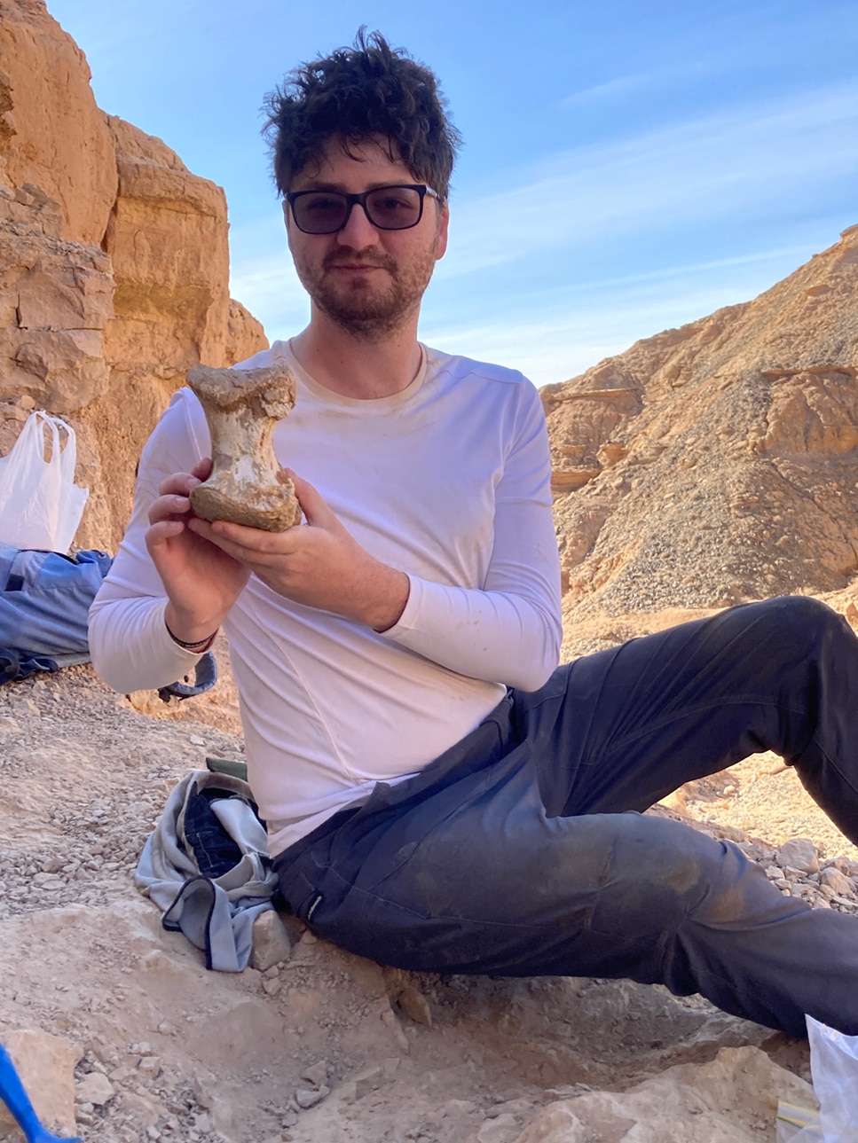 A man holding a dinosaur bone