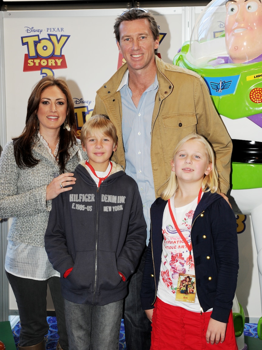 A man and woman and children stand in front of promotional stand for Toy Story 3