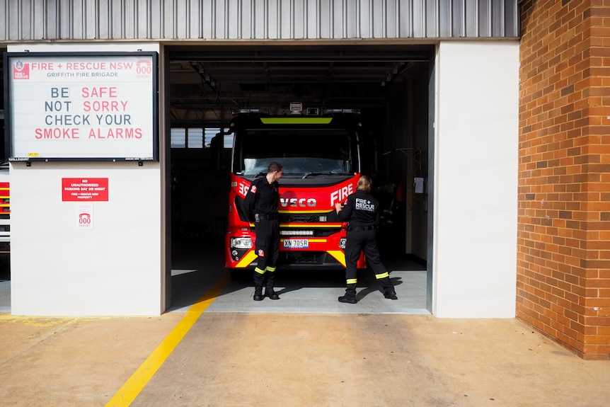 A fire truck and two fire fighters at the Griffith fire station.