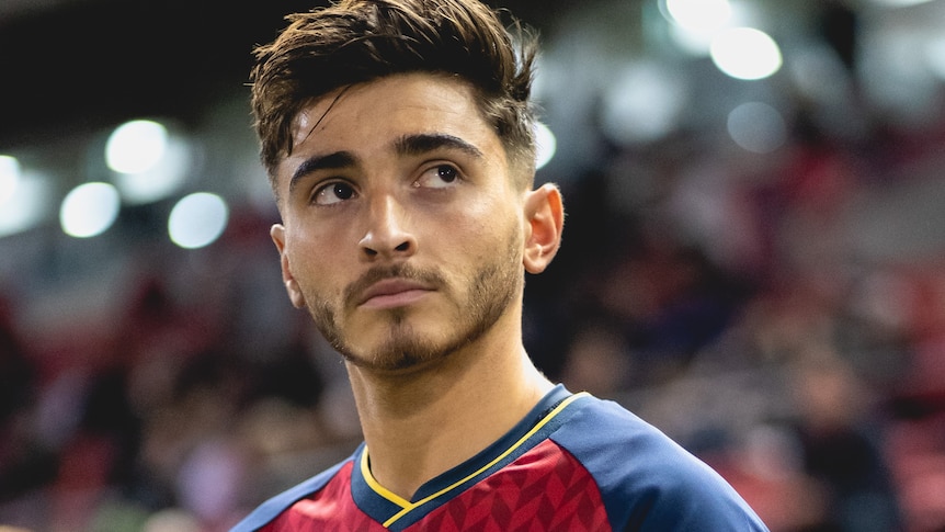 Adelaide United's Josh Cavallo looks up at the crowd while walking onto the field.