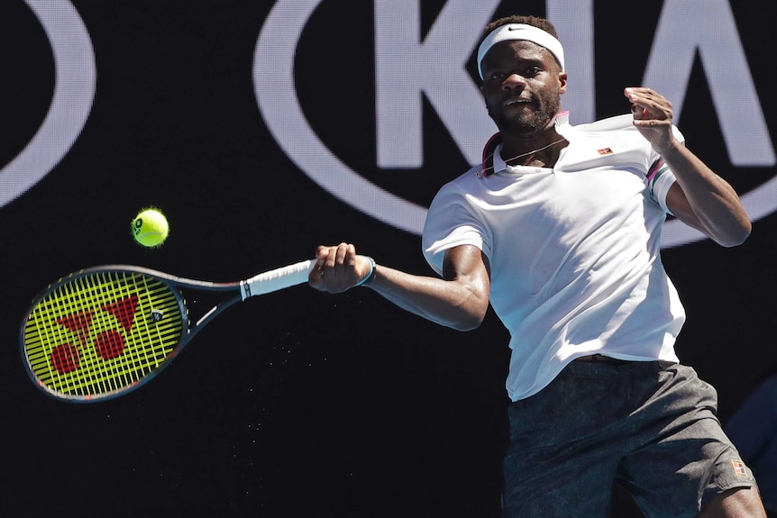 A men's player stretches out to hit a forehand return at the Australian Open.