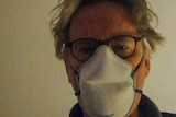 A photo of a man looking a bit dishevelled in a face mask