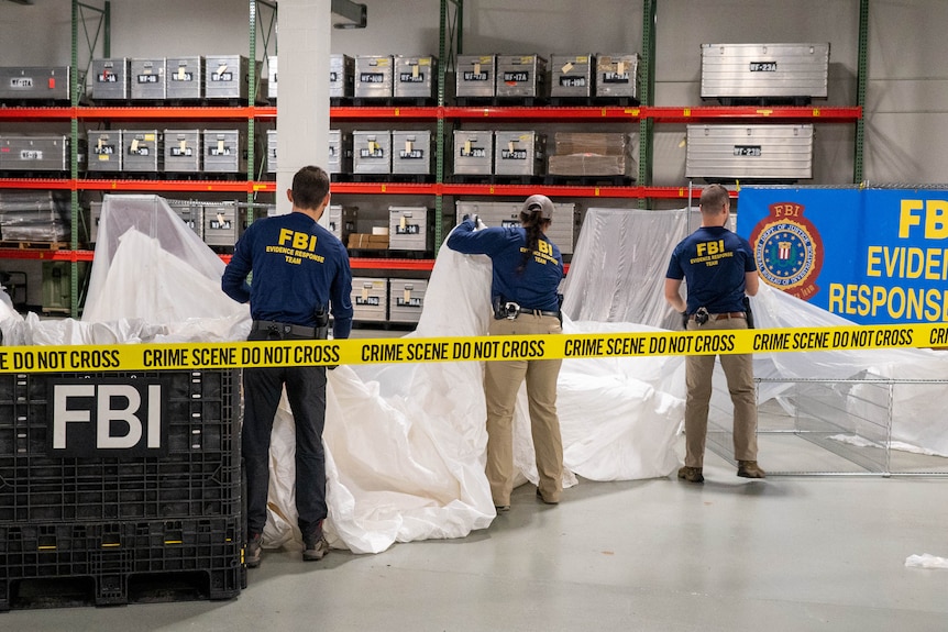 FBI agents throwing big white tarps over something