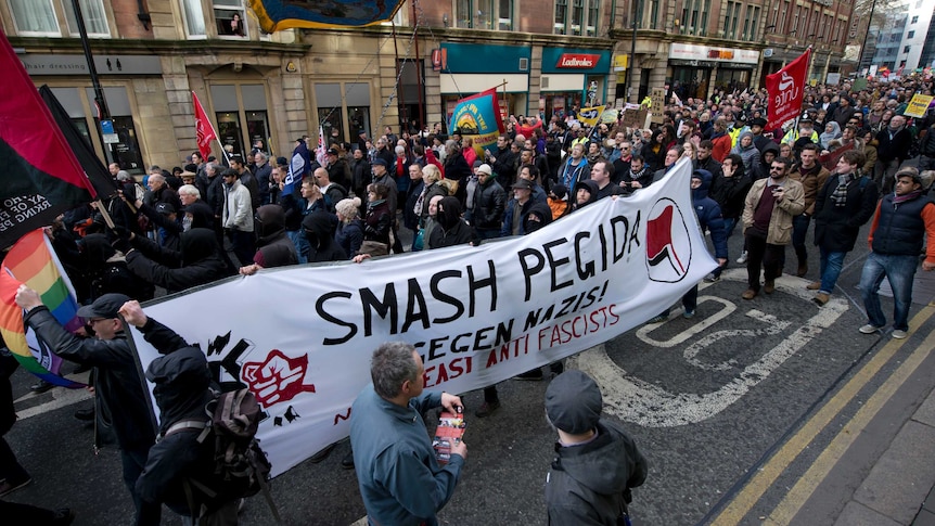 Demonstrators attend a counter-protest against PEGIDA