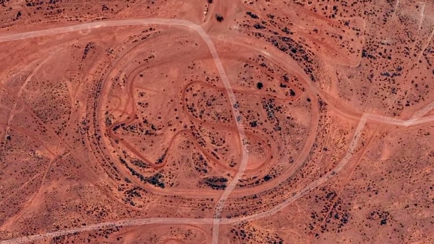 An aerial view of Broken Hill's old speedway track. Dark red lines distinguish the track from the expanse of red dirt.