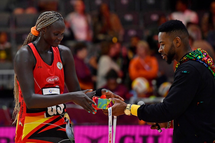 Cholhok is handed a medal by an MC in Cape Town