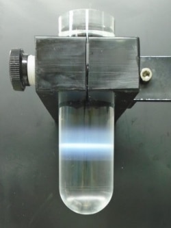 The clear "test tube" (actually a centrifuge tube), held in the clamp, contains one-sixth of the total first vaccine batch.